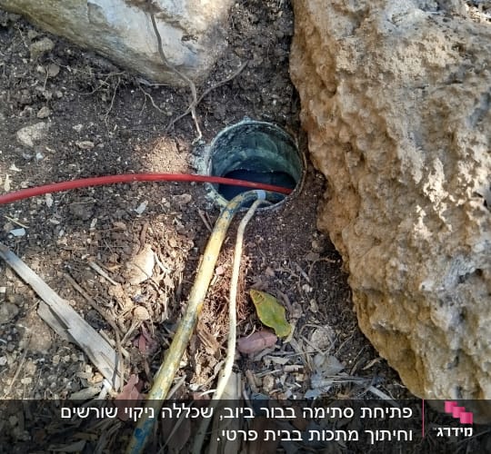 צינורות וחור באדמה ליד סלעים